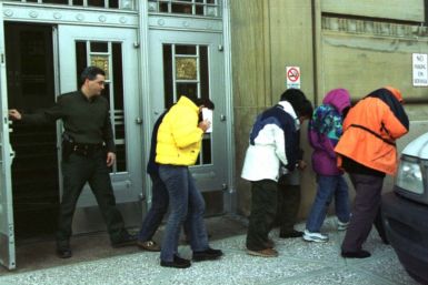 U.S. Immigration officers escort six Chinese citizens from Federal Court in Buffalo as they were ordered returned to Canada where they will await asylum.