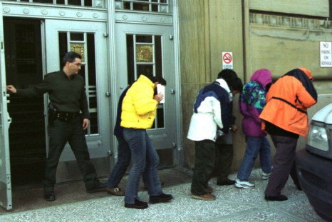 U.S. Immigration officers escort six Chinese citizens from Federal Court in Buffalo as they were ordered returned to Canada where they will await asylum.