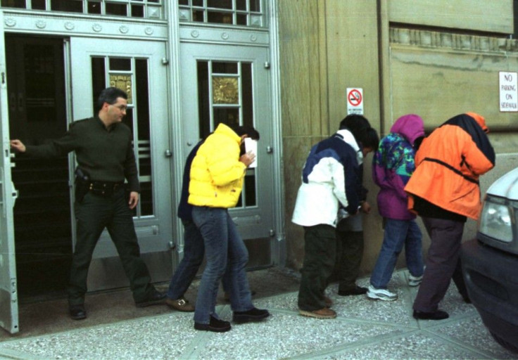 U.S. Immigration officers escort six Chinese citizens from Federal Court in Buffalo as they were ordered returned to Canada where they will await asylum.