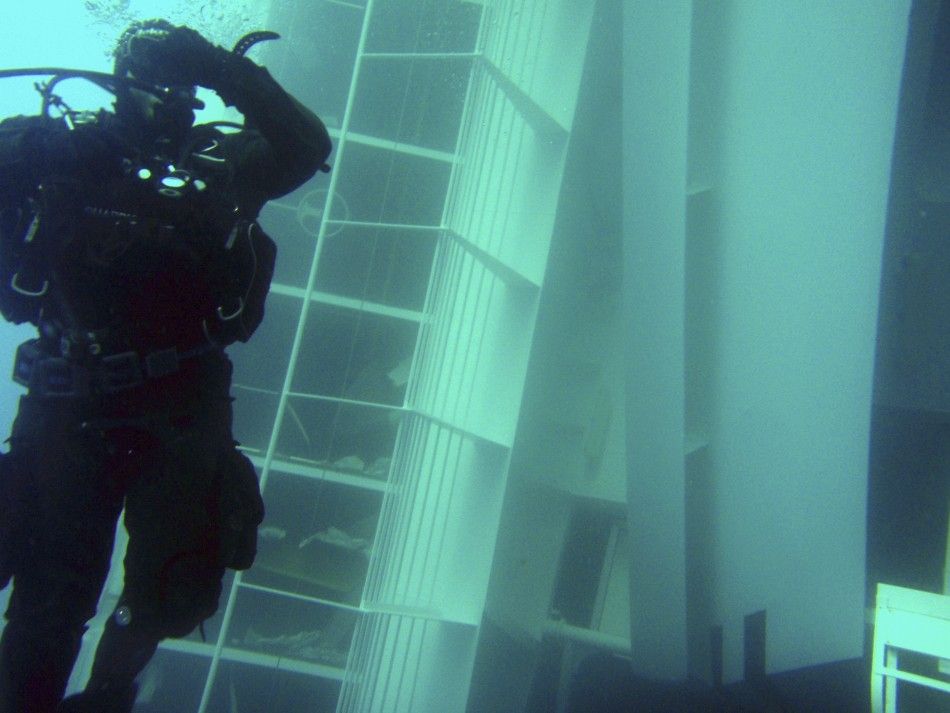 A scuba diver inspects a side of the Costa Concordia cruise ship, seen underwater after it ran aground off the west coast of Italy, at Giglio island