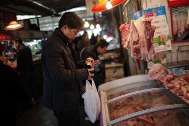A man buys meat at a local food market in Shanghai