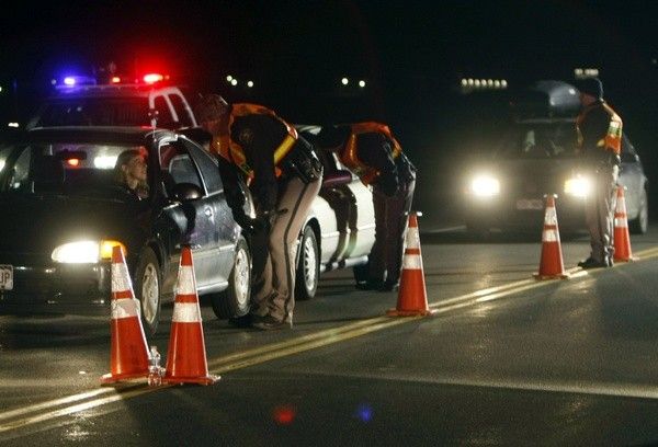 Jefferson County Sheriff Department officers ask drivers if they have been drinking while smelling for alcohol at a mobile Driving Under the Influence DUI checkpoint in Golden, Colorado. 