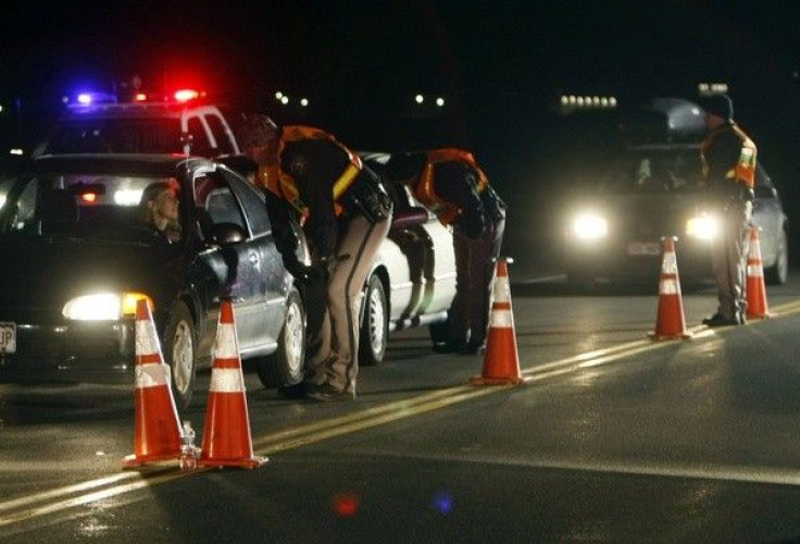 Jefferson County Sheriff Department officers ask drivers if they have been drinking while smelling for alcohol at a mobile Driving Under the Influence (DUI) checkpoint in Golden, Colorado. 