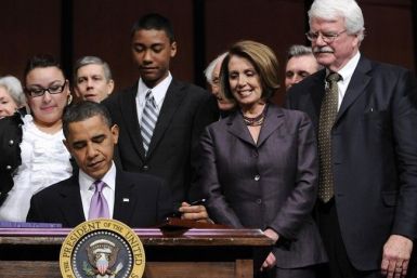 House Speaker Nancy Pelosi (D-CA) (2nd R) and Rep. George Miller (D-CA) (R) look on as U.S. President Barack Obama signs the Health Care and Education Reconciliation Act into law at Northern Virginia Community College in Alexandria, Virginia, March 30, 20