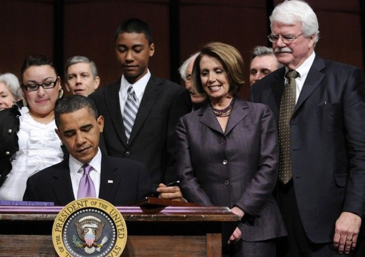 House Speaker Nancy Pelosi (D-CA) (2nd R) and Rep. George Miller (D-CA) (R) look on as U.S. President Barack Obama signs the Health Care and Education Reconciliation Act into law at Northern Virginia Community College in Alexandria, Virginia, March 30, 20