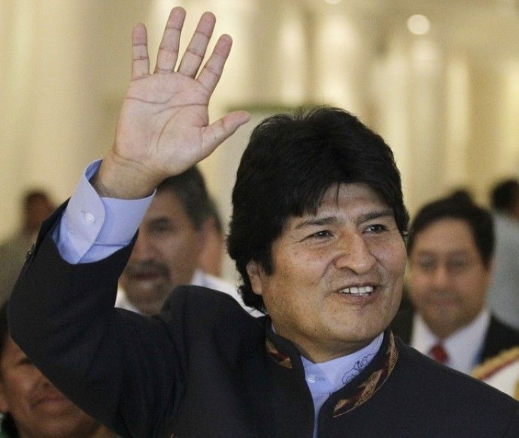 Bolivia's President Morales waves as he arrives to attend a plenary session at the Moon Palace, where climate talks are taking place, in Cancun
