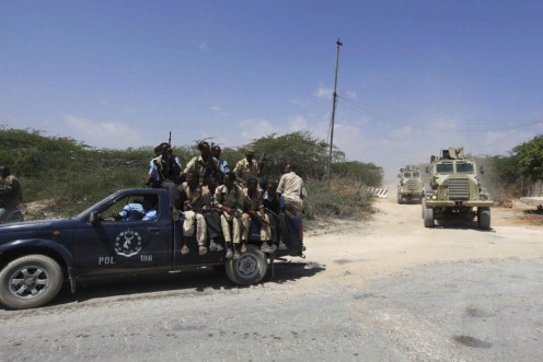 Somalia government soldiers and Ugandan peacekeepers from AMISOM patrol a road following an encounter with Islamist militia in Mogadishu