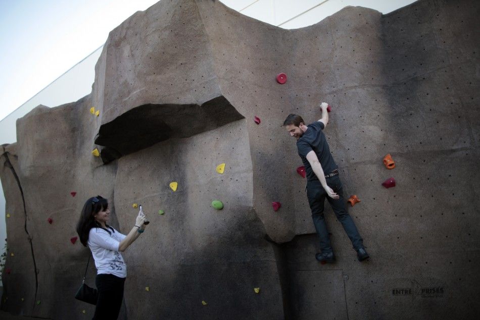 Systems Integrator Scott is photographed by his girlfriend Pynes as he tries out the rock climbing wall at the Google campus near Venice Beach, in Los Angeles