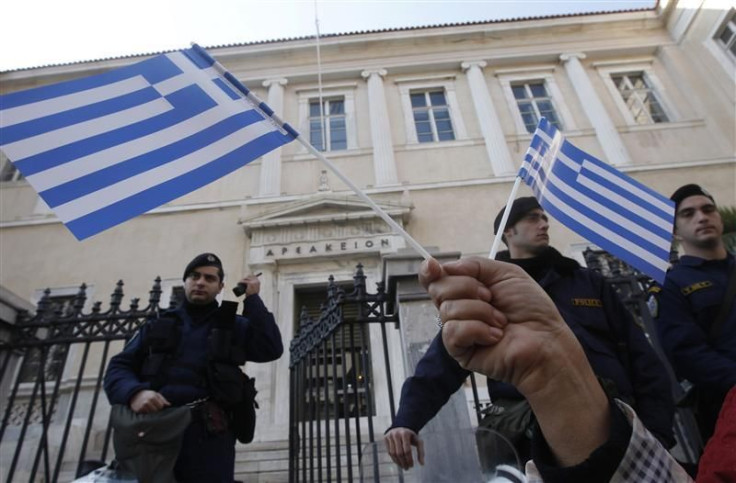 A protester holds Greek flags during a demonstration against a new property tax which has been included to the Greece's PPC bill to consumers in Athens.