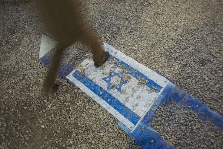 EDITORS' NOTE: Reuters and other foreign media are subject to Iranian restrictions on leaving the office to report, film or take pictures in Tehran. An Iranian man walks on an Israeli flag while visiting a war exhibition held by Iran's revolutio