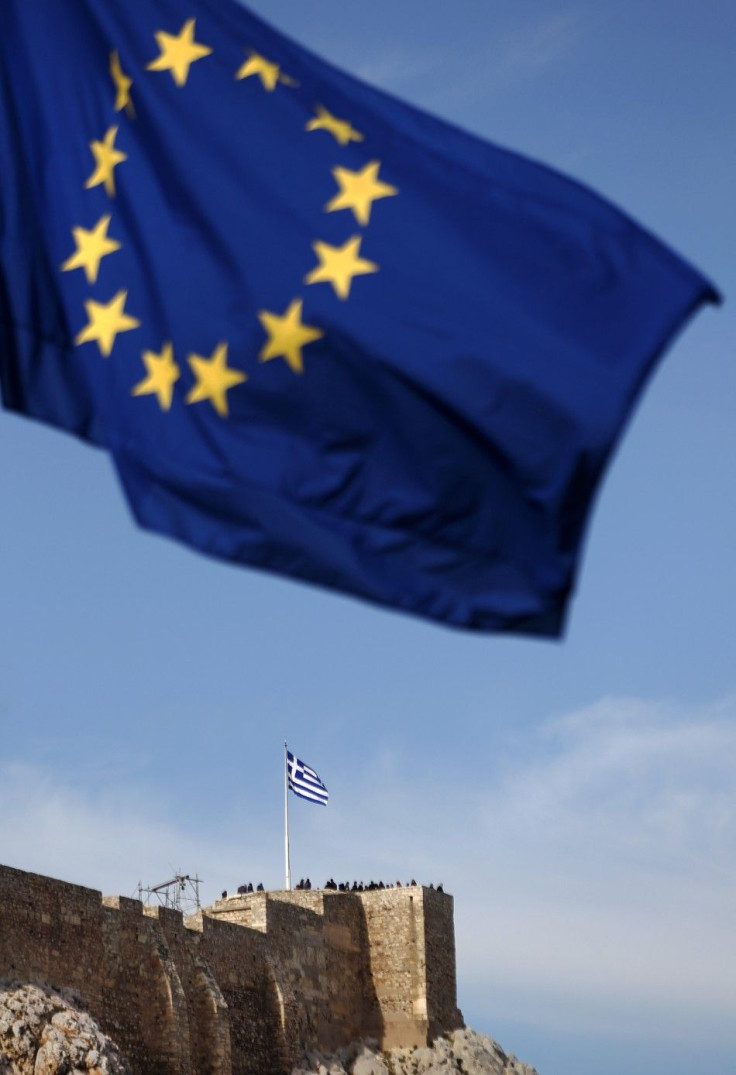 An European Union flag flies as tourists visit the ancient hill of the Acropolis in Athens January 20, 2012.