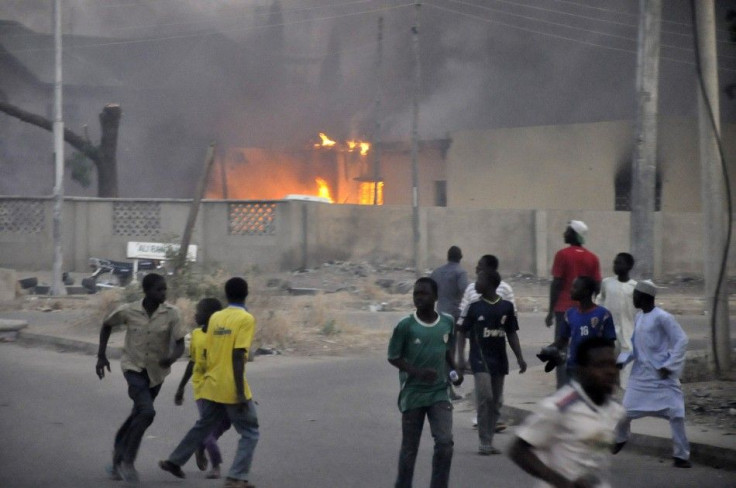 Smoke rises from the police headquarters as people run for safety in Nigeria's northern city of Kano January 20, 2012.