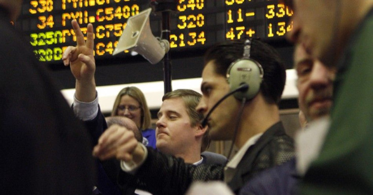 Traders in the Corn options pit at the CME Group signal orders shortly before the closing bell in Chicago, February 11, 2011.