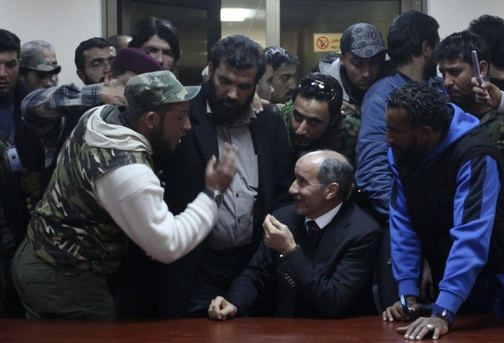Chairman of the Libyan National Transitional Council (C) Abdul Jalil talks to protesters, who were wounded from the war, at the NTC headquarters in Benghazi January 21, 2012.