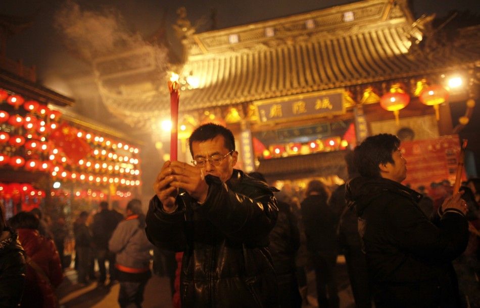 A man holds incense sticks as part of Chinese new year celebrations at the Old City God Temple in Yuyuan Garden in Shanghai 