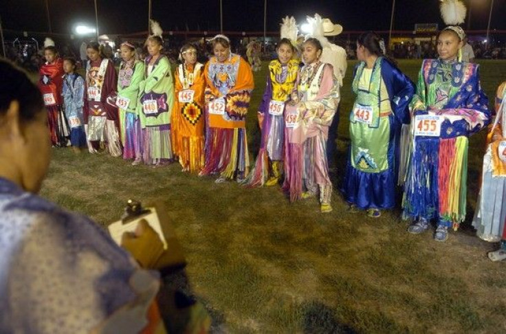 Native American dancers stand by as a judge (L) gives her final marks during a competition at the Oglala Nation Pow Wow and Rodeo in Pine Ridge, South Dakota, August 4, 2006.