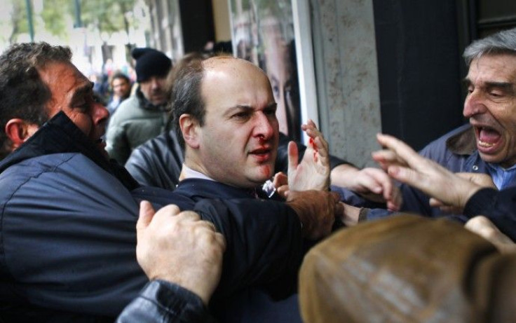 Former conservative minister Kostis Hatzidakis reacts after being attacked by leftists with their fists, stones and sticks, while they shouted: &quot;Thieves! Shame on you!&quot; during a march against austerity measures in central Athens