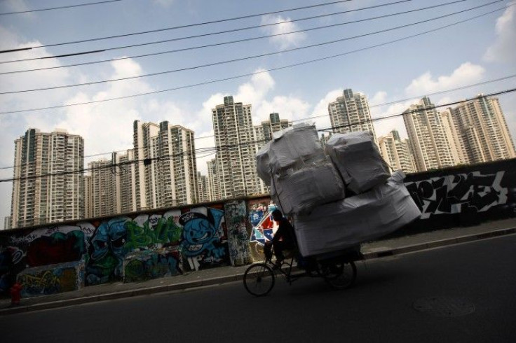 A man rides his tricycle past a residential site in Shanghai