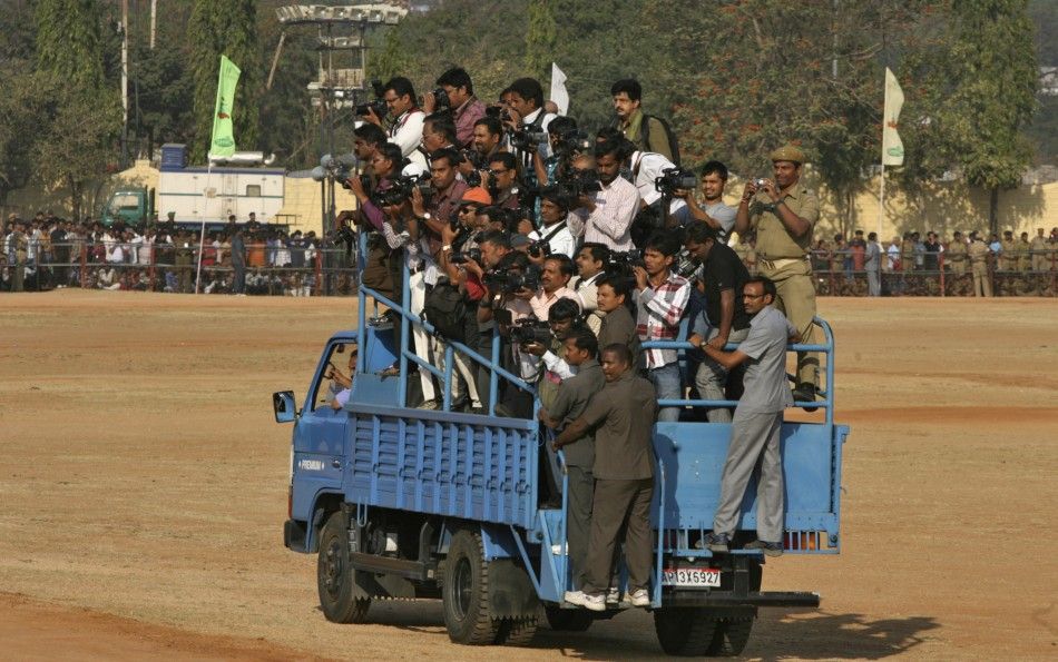 News and media crew members stand on an open truck to take pictures of the Republic Day celebrations in Hyderabad