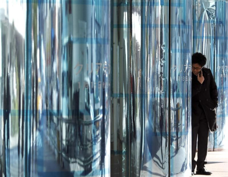 Man uses a mobile phone among advertisements of a department store in Tokyo