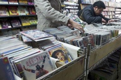 Customers select pirated DVDs at a store in Xiangyang, Hubei province December 14, 2010.