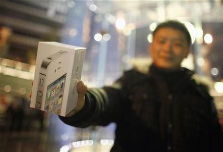 A customer show his new iPhone 4S after making the purchase at Apples retail store in downtown Shanghai January 13, 2012.