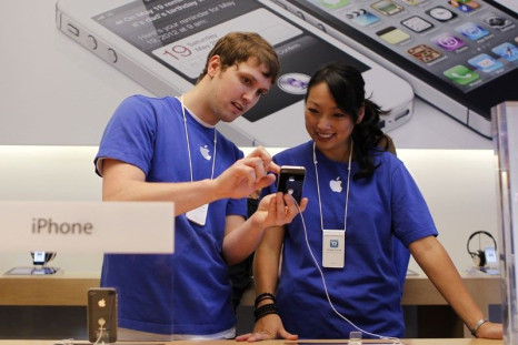 Apple employees look over the new iPhone 4S at Apple&#039;s flagship retail store in San Francisco