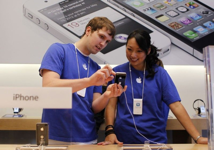 Apple employees look over the new iPhone 4S at Apple&#039;s flagship retail store in San Francisco