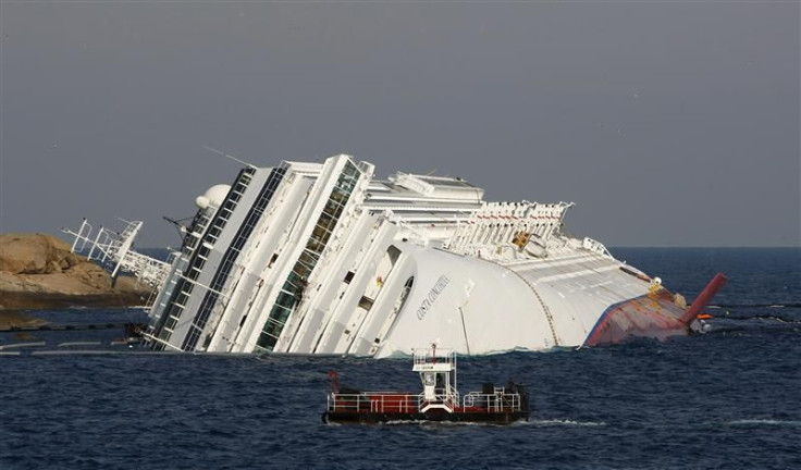 A vessel sails past the cruise liner Costa Concordia, which ran aground off the west coast of Italy, at Giglio island