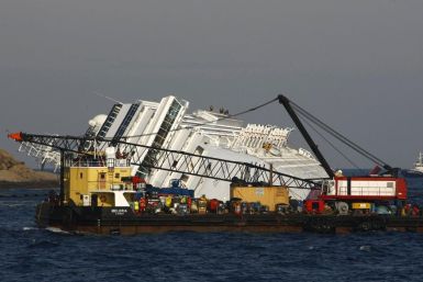 An oil recovery sea platform is towed to harbour from near the cruise liner Costa Concordia, which ran aground off the west coast of Italy, at Giglio island January 28, 2012.