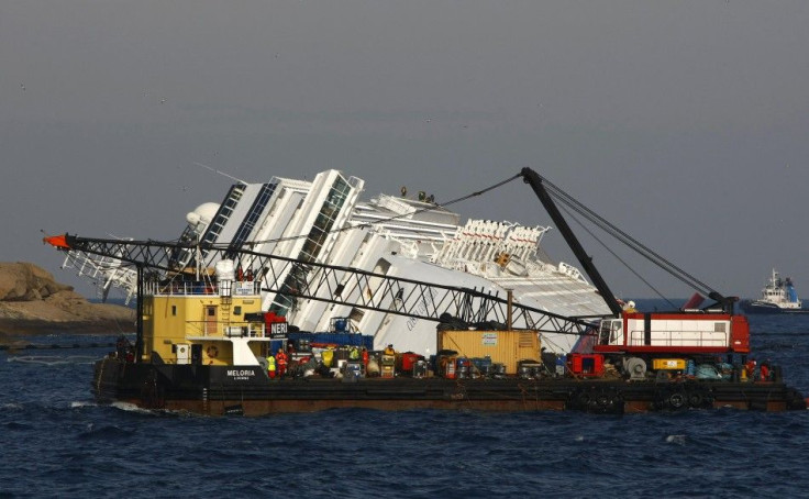 An oil recovery sea platform is towed to harbour from near the cruise liner Costa Concordia, which ran aground off the west coast of Italy, at Giglio island January 28, 2012.