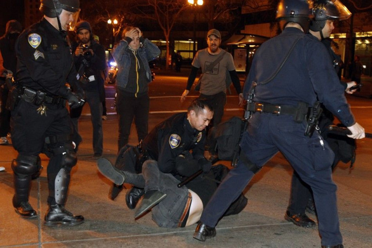 A group of police officers from various law enforcement agencies arrest an Occupy Oakland demonstrator near Frank H. Ogawa Plaza during a day-long protest in Oakland, California January 28, 2012.