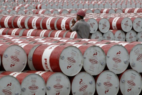 A worker walks in between oil barrels at Pertamina's storage depot in Jakarta, Indonesia, on Jan. 26, 2011.