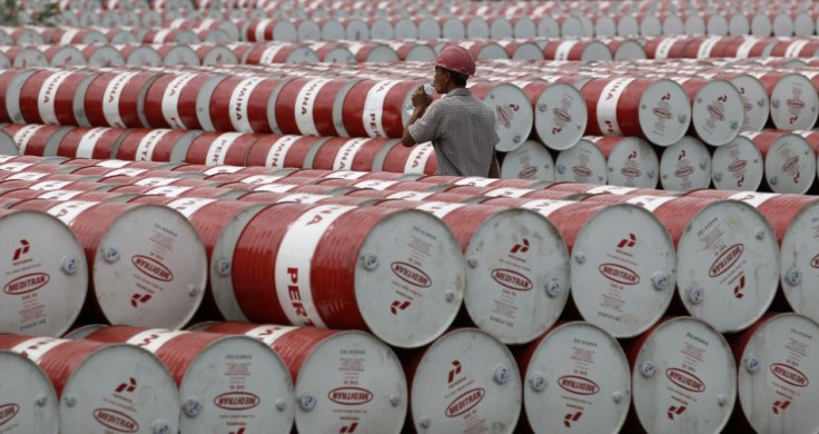 A worker walks in between oil barrels at Pertamina's storage depot in Jakarta, Indonesia, on Jan. 26, 2011.