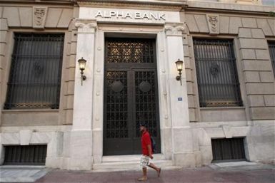 A man walks in front of the headquarters of Alpha Bank in Athens