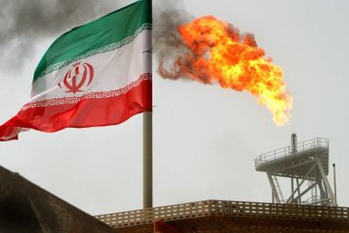 Gas flares from an oil-production platform in Persian Gulf at the Soroush oil fields with an Iranian flag in the foreground, about 776 miles south of the country's capital of Tehran