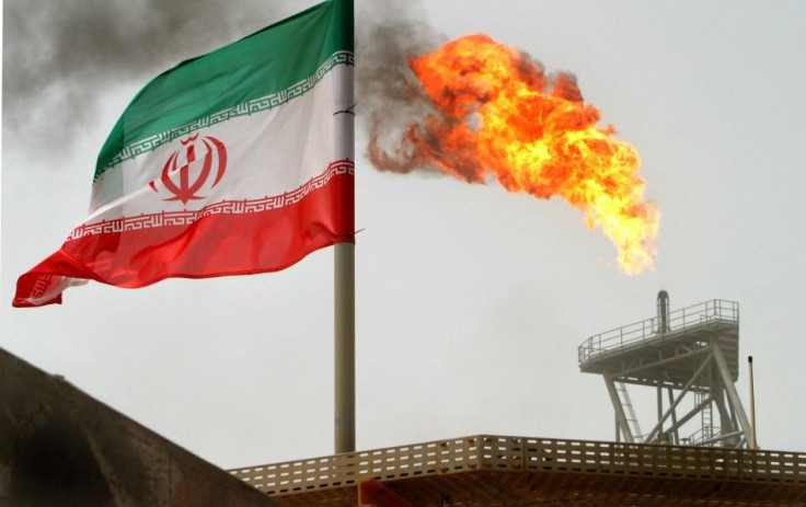 Gas flares from an oil-production platform in Persian Gulf at the Soroush oil fields with an Iranian flag in the foreground, about 776 miles south of the country's capital of Tehran