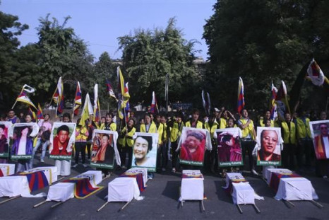 Tibetan exiles holding portraits of Tibetan protesters whom they said were killed during demonstrations in China&#039;s Sichuan province, stand behind mock coffins during a protest in New Delhi