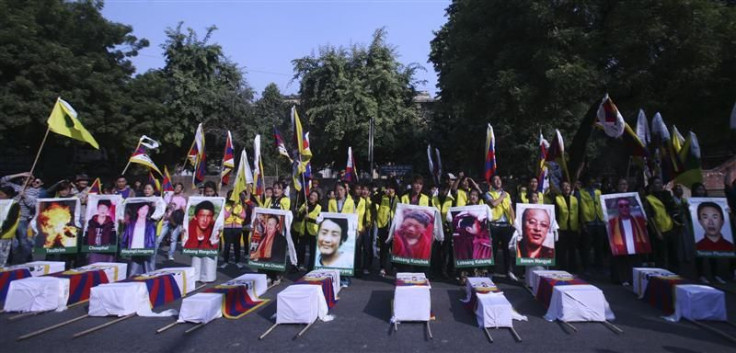 Tibetan exiles holding portraits of Tibetan protesters whom they said were killed during demonstrations in China&#039;s Sichuan province, stand behind mock coffins during a protest in New Delhi