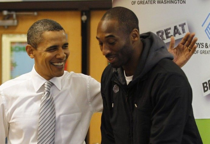U.S. President Barack Obama slaps Kobe Bryant on the back as they put together care packages for the military