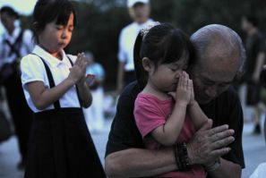 A family prays for the victims of the atomic bombing by the U.S., in the Peace Memorial Park in Hiroshima