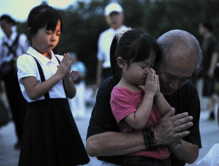 A family prays for the victims of the atomic bombing by the U.S., in the Peace Memorial Park in Hiroshima