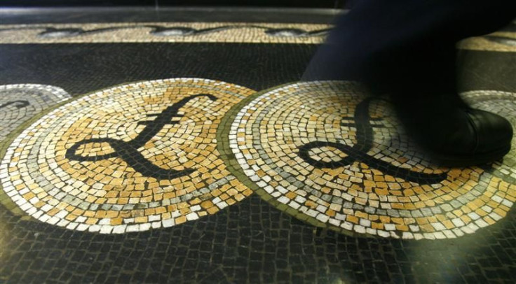 File photograph shows an employee walking over a mosaic depicting pound sterling symbols on the floor of the front hall of the Bank of England in London