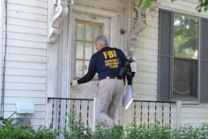 An FBI agent enters a house where a suspect was taken into federal custody earlier in the day, in Watertown, Massachusetts May 13, 2010.