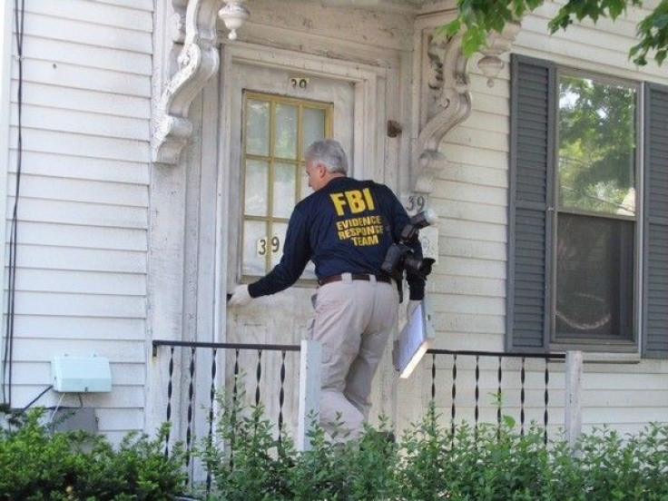 An FBI agent enters a house where a suspect was taken into federal custody earlier in the day, in Watertown, Massachusetts May 13, 2010.
