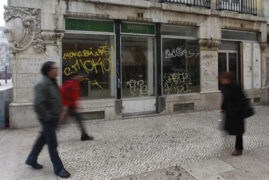 People walk near a closed down shop in downtown Lisbon