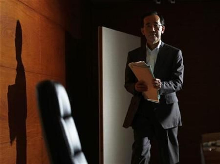 Bank of Japan Governor Masaaki Shirakawa enters a room for a news conference at the Bank of Japan in Tokyo