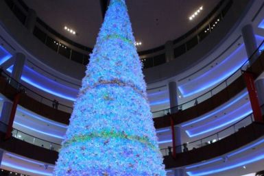 People walk past a Christmas tree at Dubai mall in Dubai December 25, 2009.