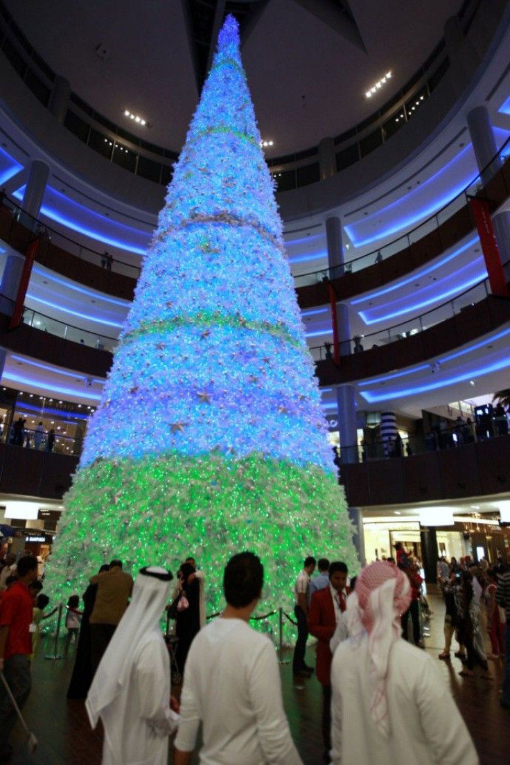 People walk past a Christmas tree at Dubai mall in Dubai December 25, 2009.