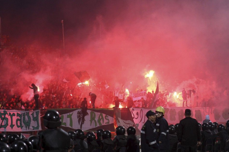 Police officers react as chaos erupts at a soccer stadium in Port Said city